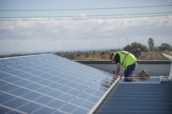 Person on roof installing solar panels