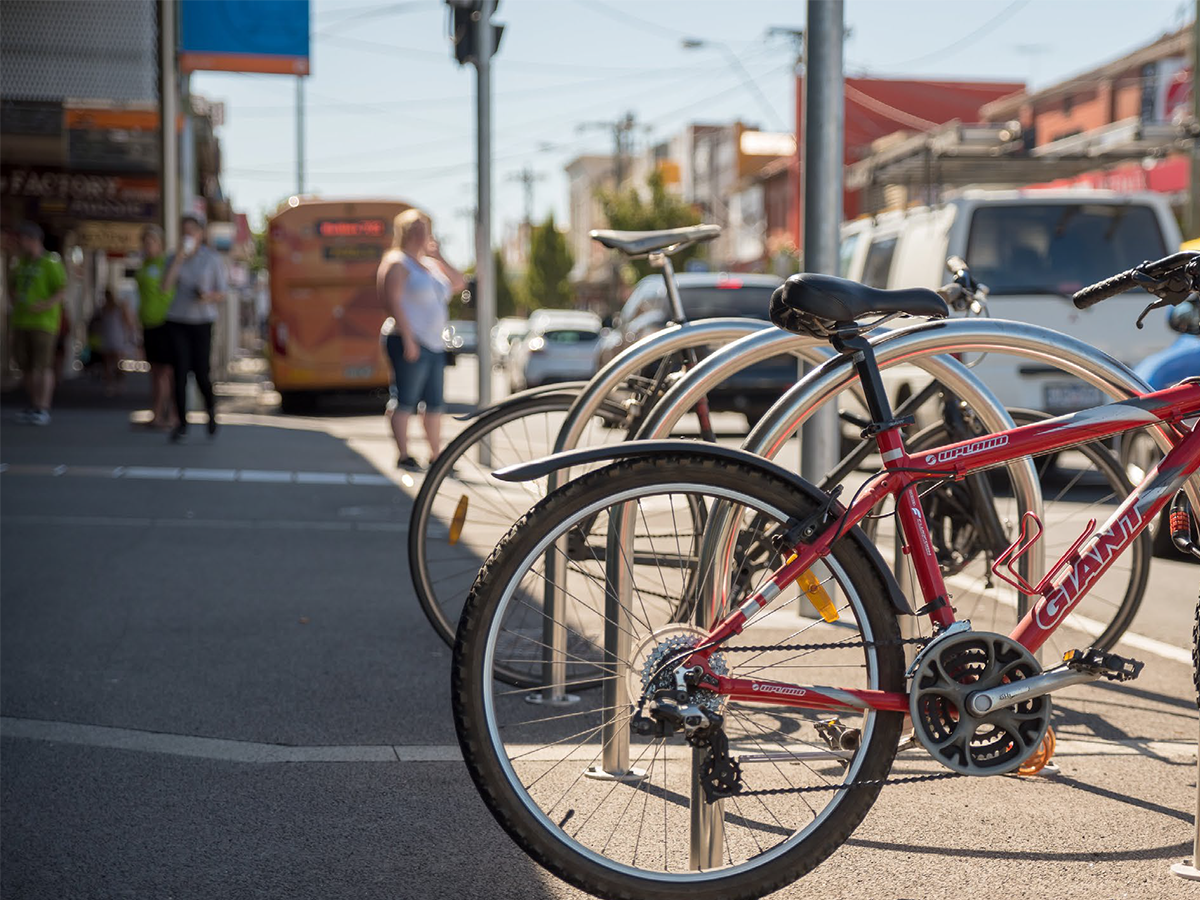 Footpath, bike parking, street with cars and a bus