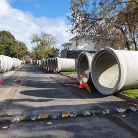 Sections of concrete drainage pipe flank Kalimna Street in preparation for installation at King George VI Memorial Reserve car park.