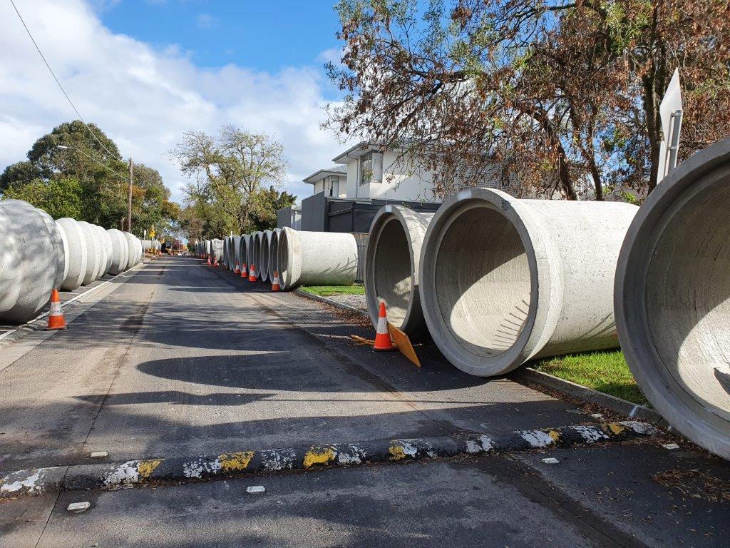 Sections of concrete drainage pipe flank Kalimna Street in preparation for installation at King George VI Memorial Reserve car park.