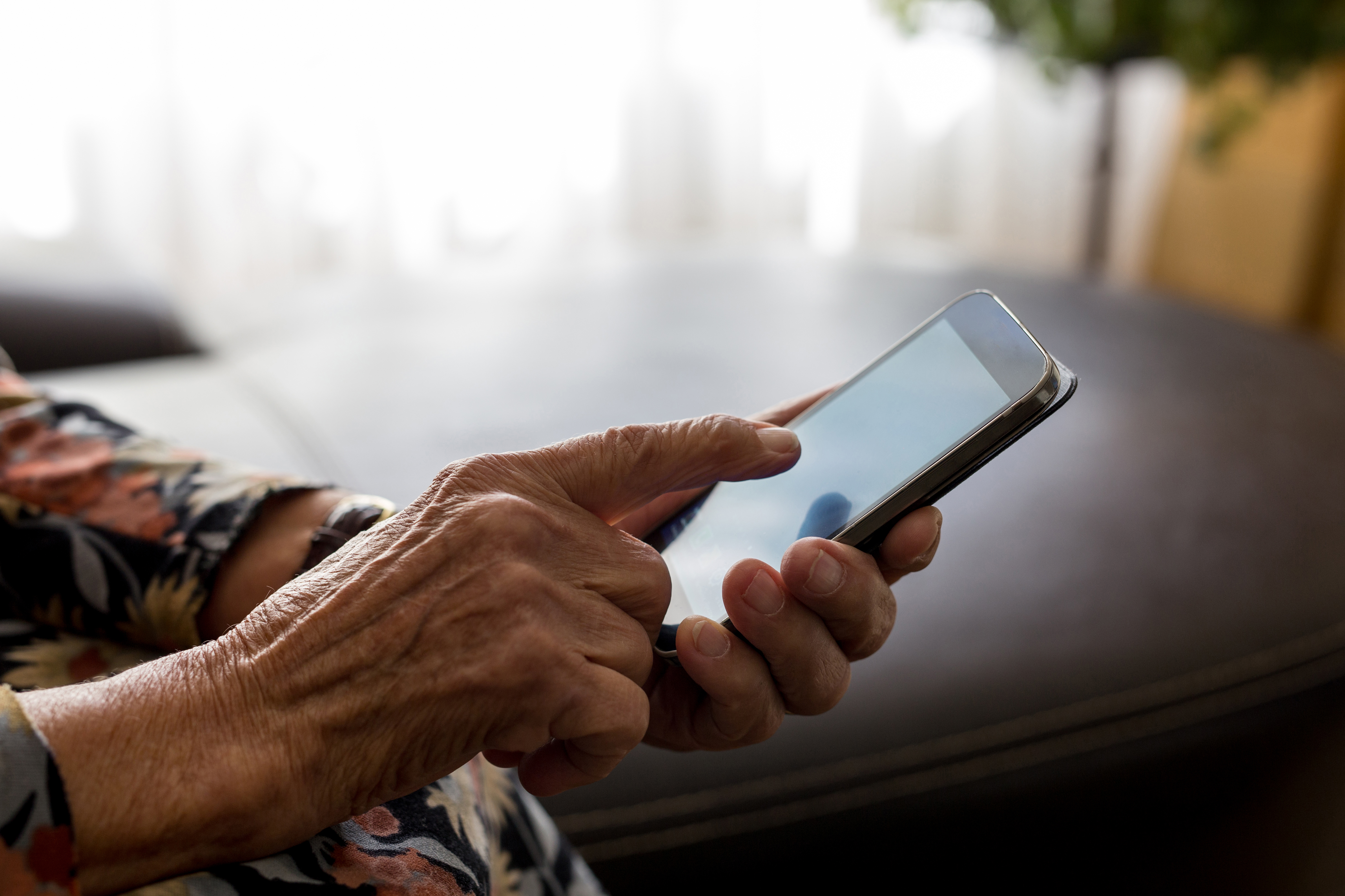 Older adult using a smartphone, highlighting digital skills, technology assistance and everyday app use.