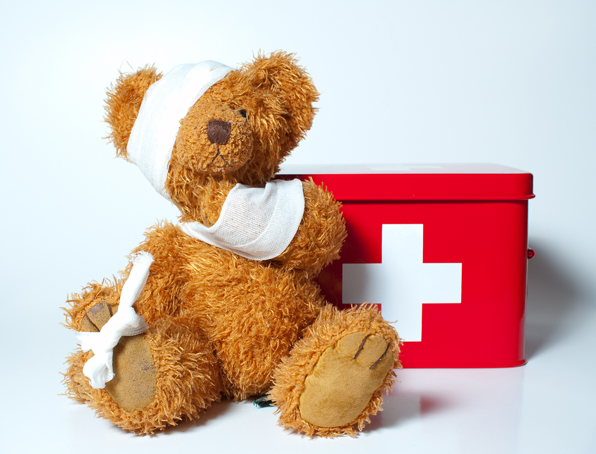 Teddy bear with bandages with a first aid kit