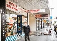 Person walking past the Blight's Shoe Repair shop in Elsternwick