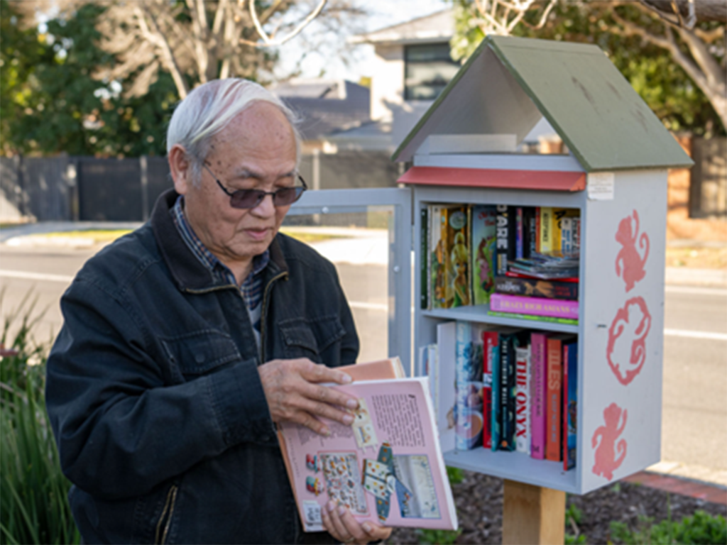 JJ a café owner organising some donated books by the community