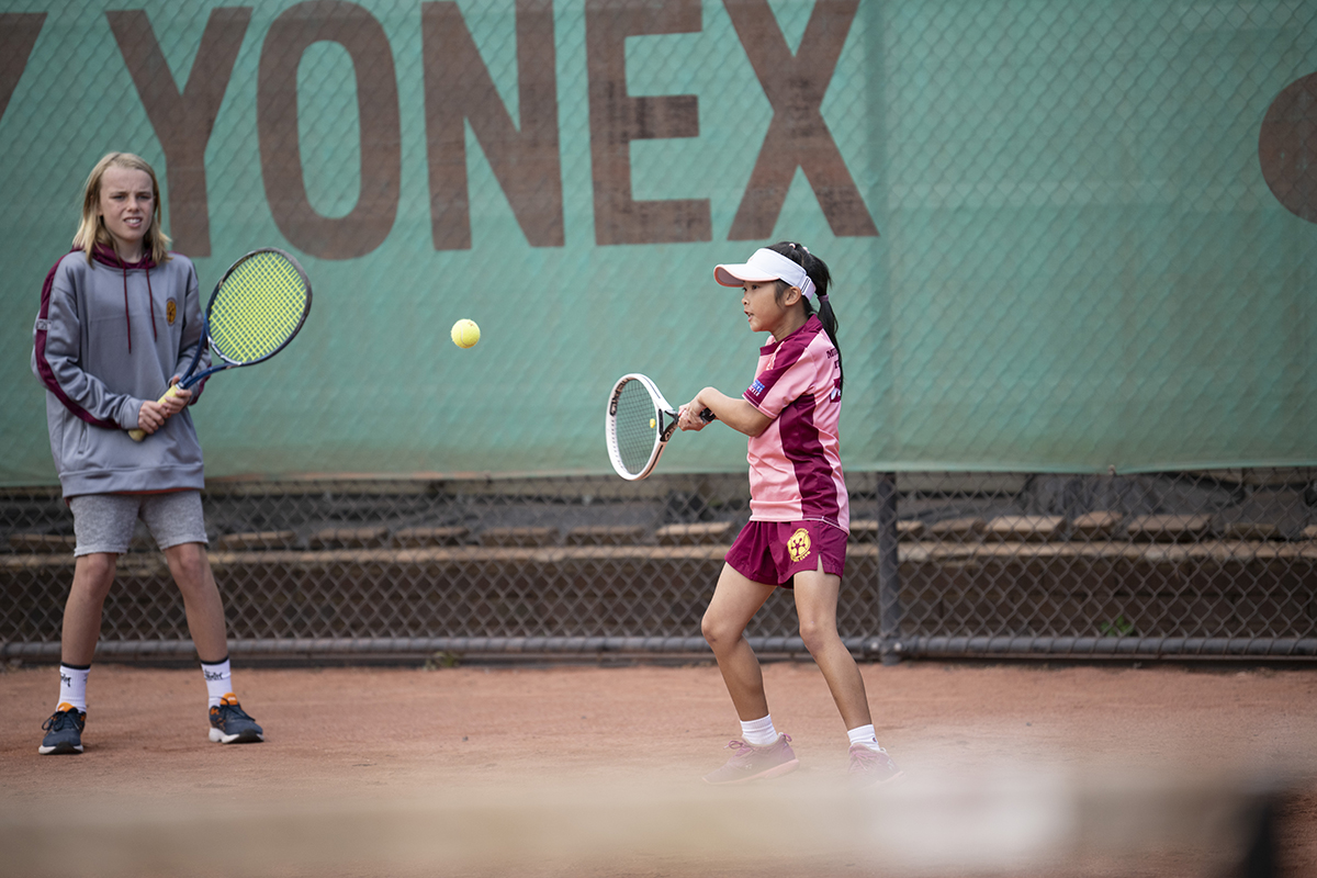 Two children playing tennis