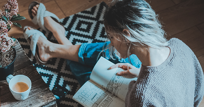 Lady reading a book while drinking coffee