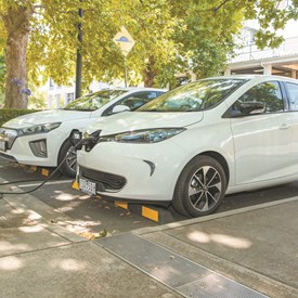 A white Renault Zoe electric car being charged and white Hyundai Ioniq parked next to it