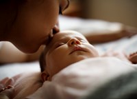 Woman kissing sleeping baby