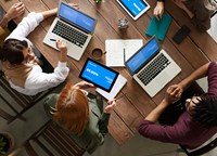 People around a table with laptops