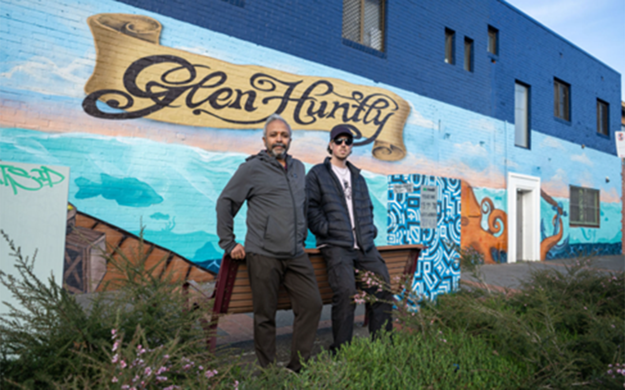 Aaron Hill and building tenant Raju at Quality Groceries