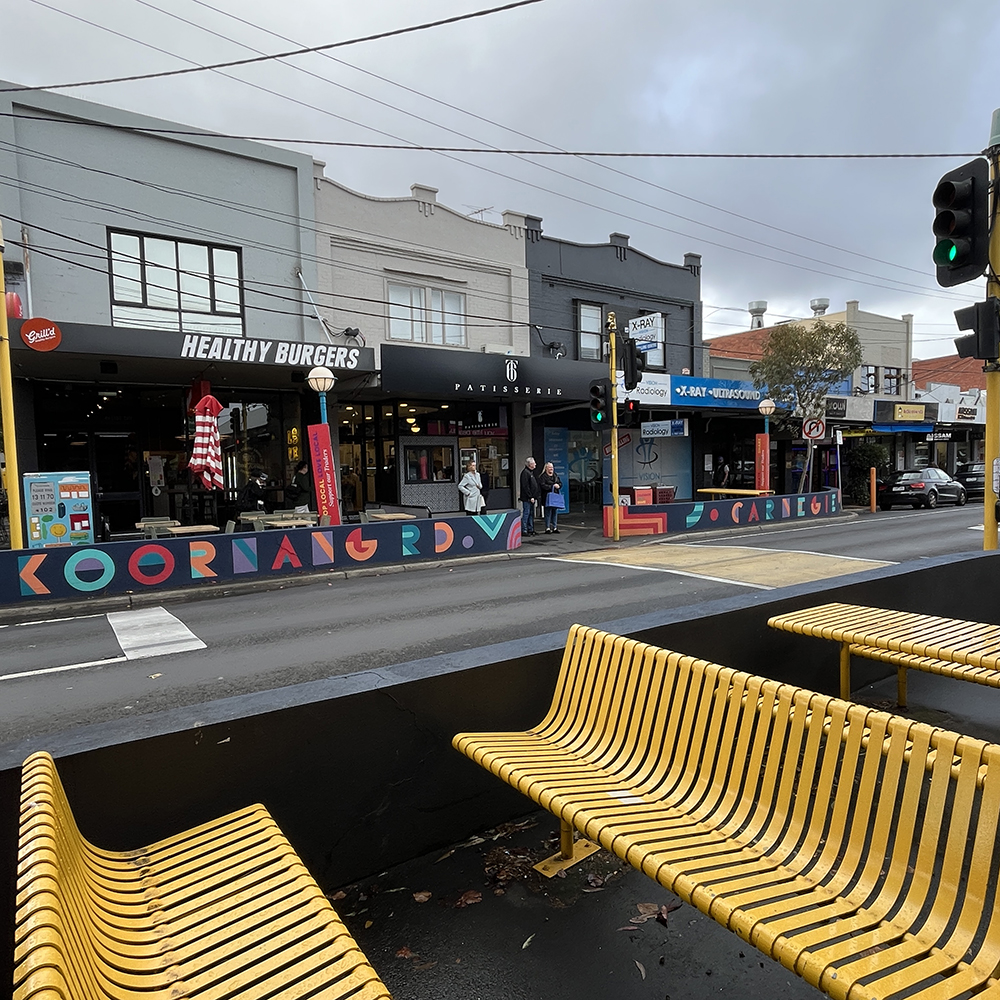 Koornang Road pedestrian crossing in Carnegie, with shops and seating