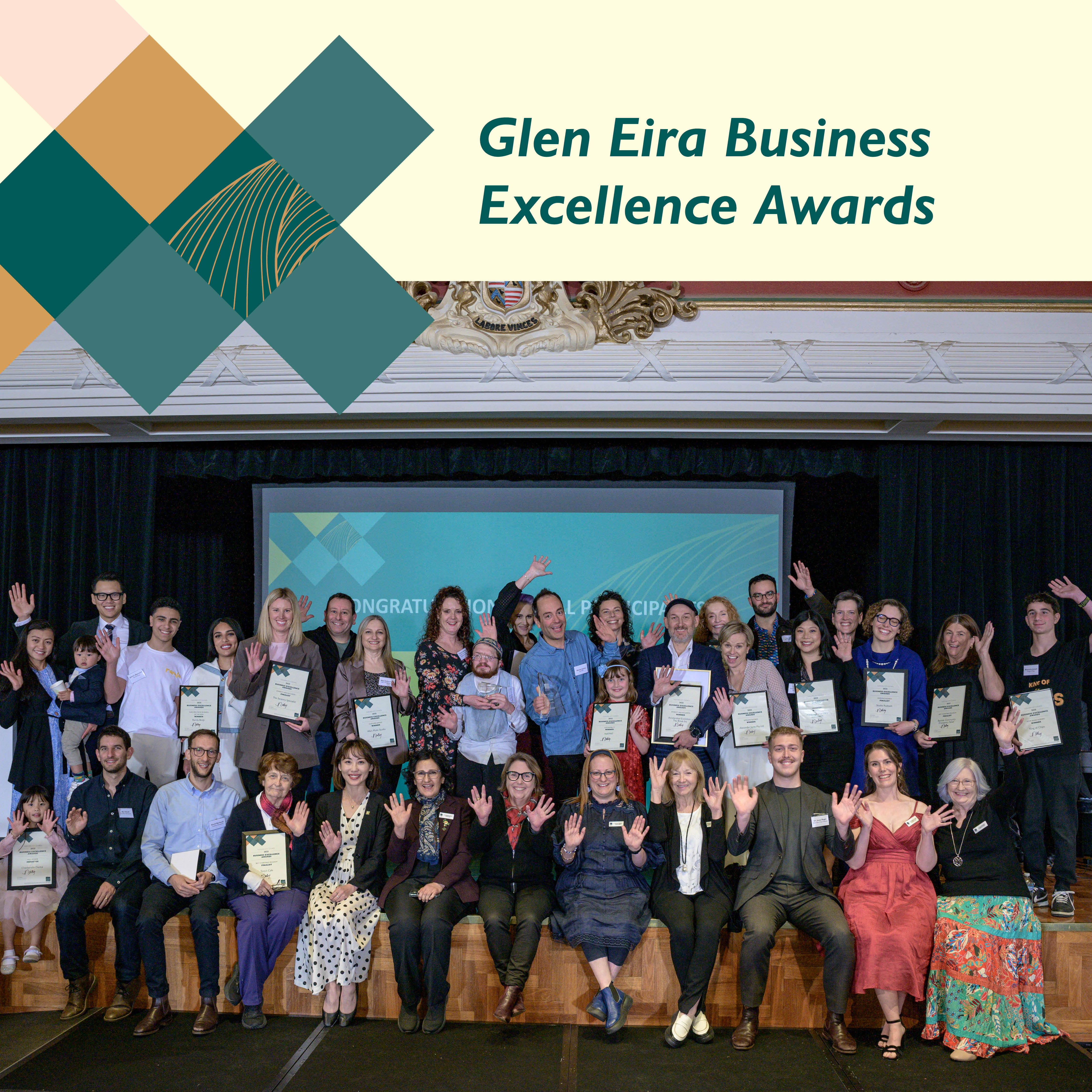 Group photo of Business Excellence Awards participants and winners on stage beneath a Glen Eira Business Excellence Awards banner.