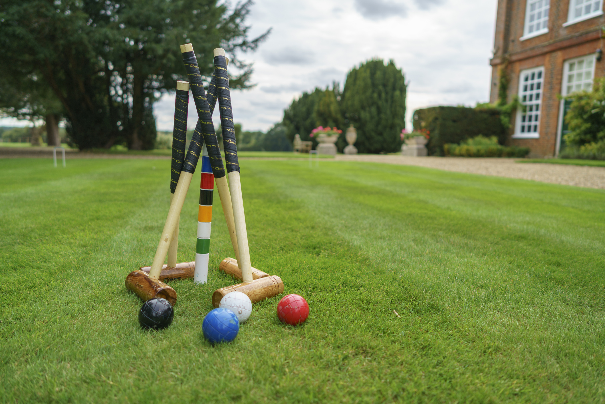 Croquet mallets, balls and a wicket set up on a lawn, ready for a game at a community croquet session.
