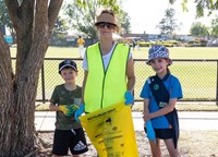 Yellow vested woman holding rubbish bag