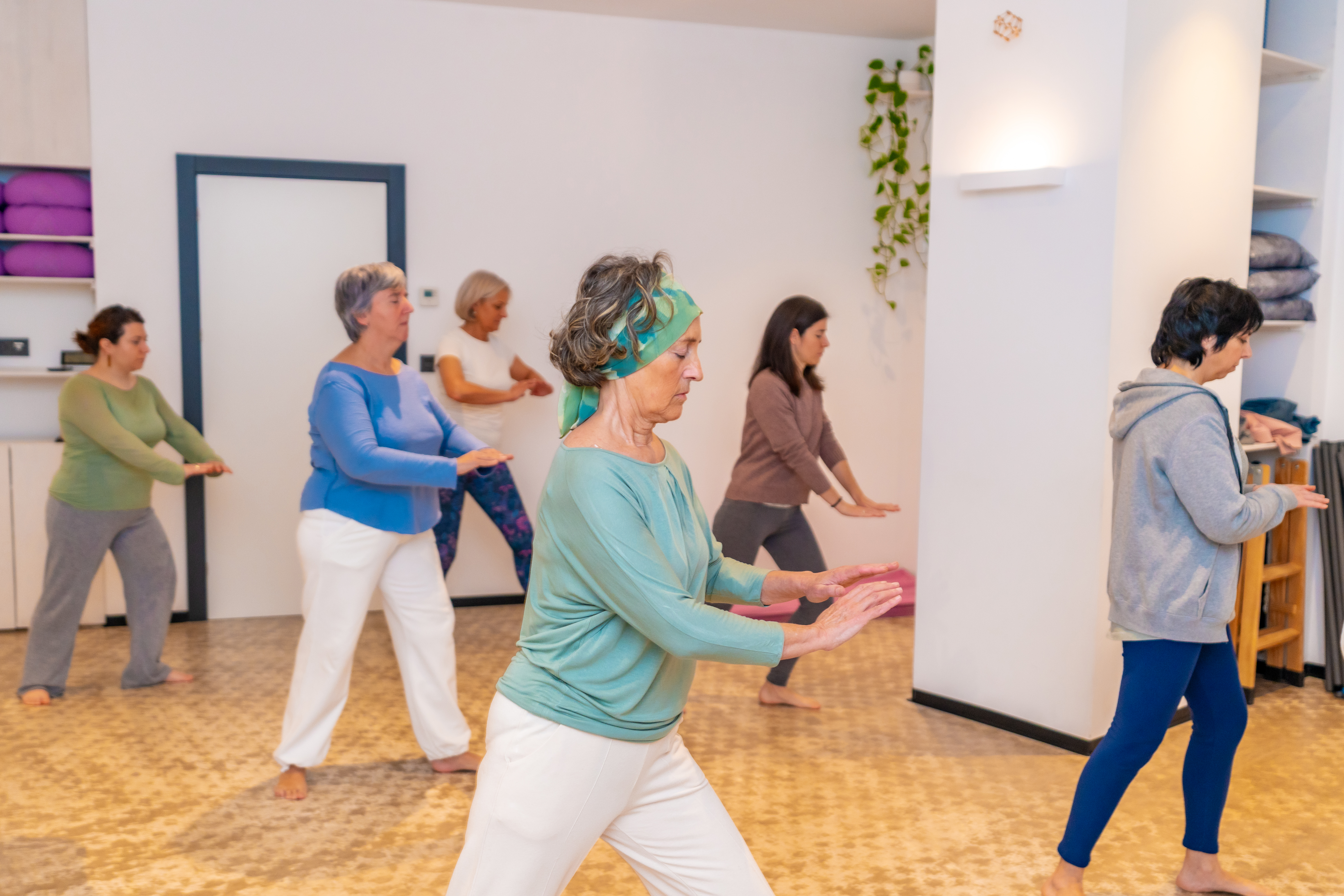 Participants practise gentle qi gong movements during a group wellbeing class.