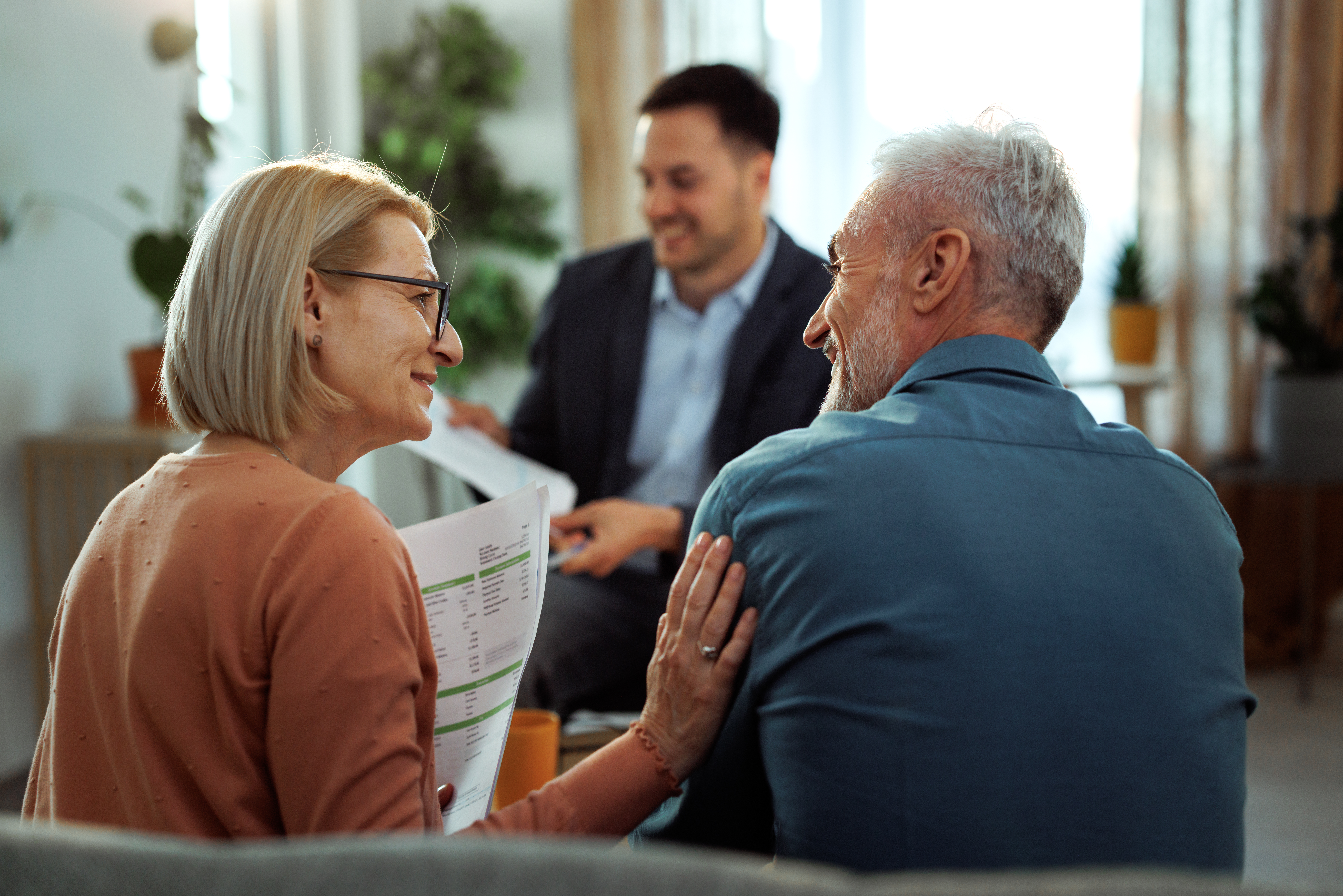 Older adults speak with an adviser during a planning ahead information session, reviewing documents and future care or financial options.