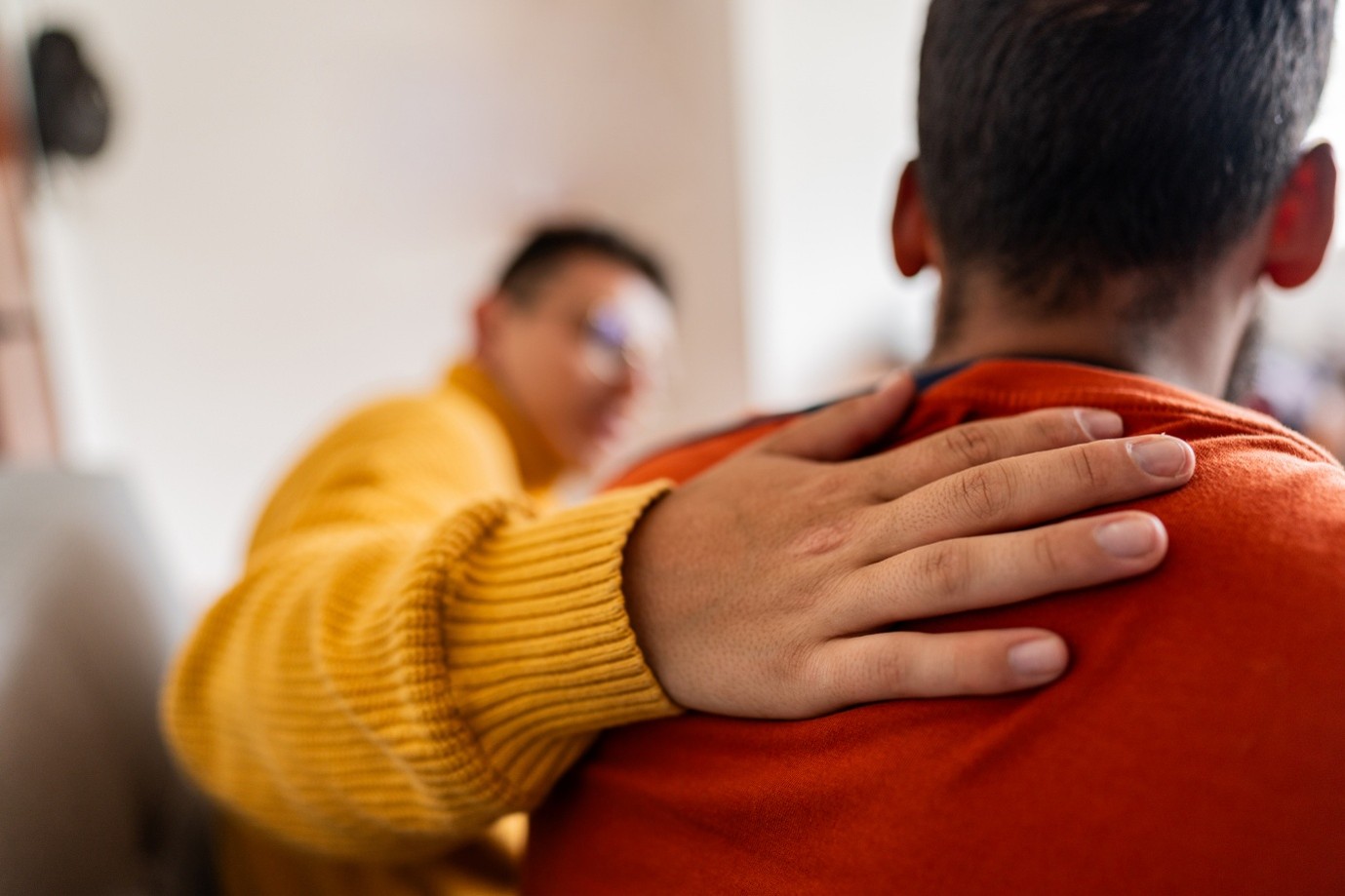 man patting the back of another man